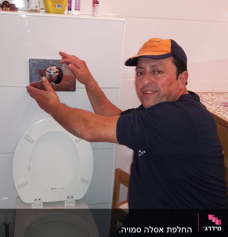 אדם מתקין לחצן ניאגרה בשירותים